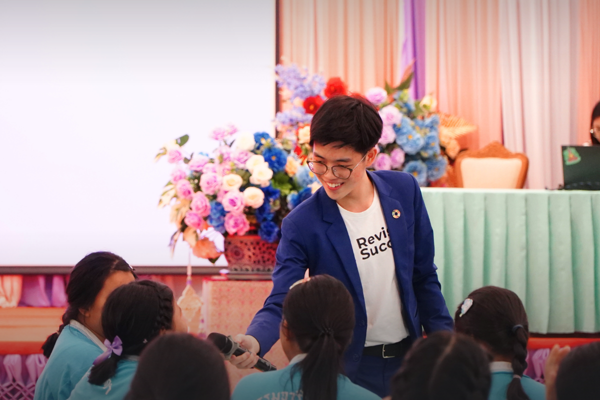 Phonlawat Sirajindapirom hands the microphone to a student during a workshop