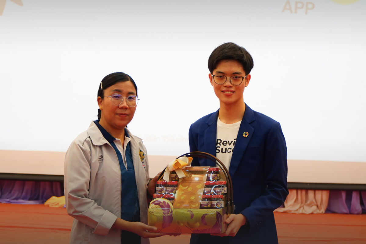 Phonlawat Sirajindapirom, Co-Founder & CEO of RevisionSuccess, presents a gift to a Dhammajarinee Witthaya School executive